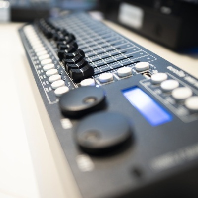 Mesa de mistura ou controlador de áudio preto com botões e visor digital azul