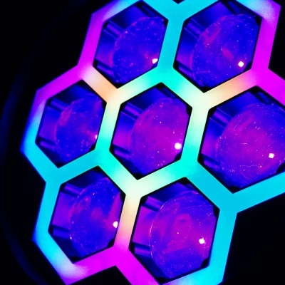 Luz LED hexagonal colorida com seis módulos iluminados em fundo escuro