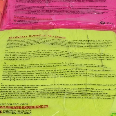 Sacos plásticos coloridos com confetes e texto impresso em várias línguas.