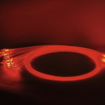 Conjunto de fibras ópticas vermelhas iluminadas com extremidades brilhantes.