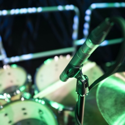 Microfone perto de bateria em palco iluminado