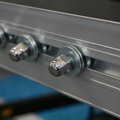 Perfil metálico prateado com quatro parafusos e porcas