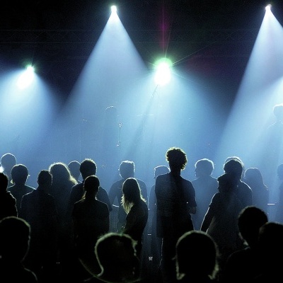 Multidão de pessoas em silhueta com luzes brilhantes ao fundo