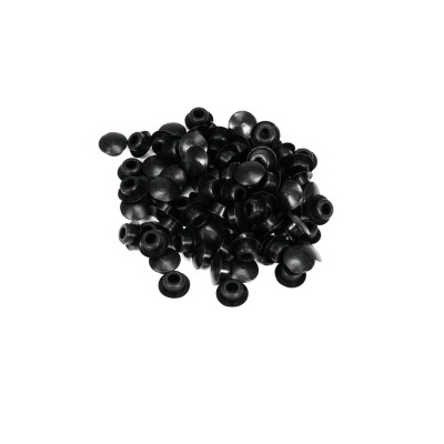 Múltiplas tampas pretas pequenas arredondadas, dispostas em fundo branco