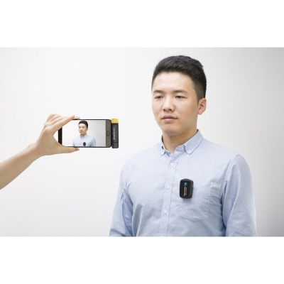 Homem com dispositivo preto preso à camisa a ser filmado por telemóvel