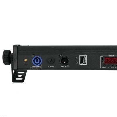 Dispositivo eletrónico preto com conexões e mostrador digital numa superfície branca