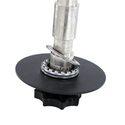 Peça metálica industrial com disco negro e componente circular com esferas