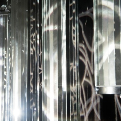 Luzes cilíndricas metálicas prateadas com reflexão em fundo escuro