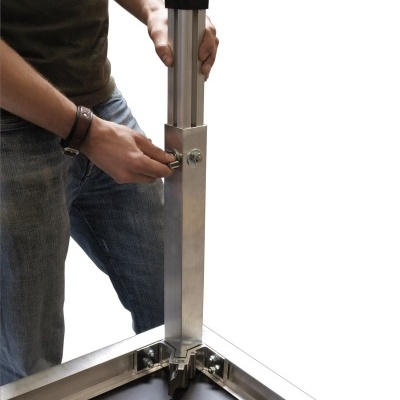 Pessoa a ajustar estrutura metálica de alumínio com parafusos