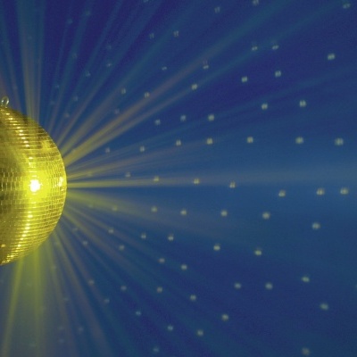 globo espelhado dourado refletindo luz numa parede azul