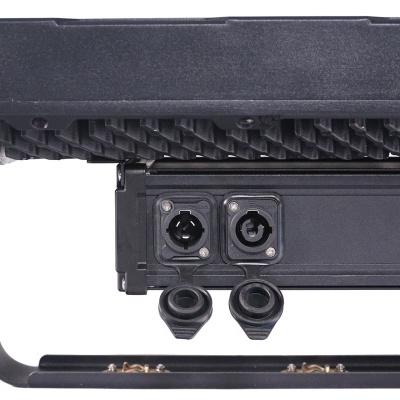 Luminária profissional preta com entradas para cabos em estrutura metálica