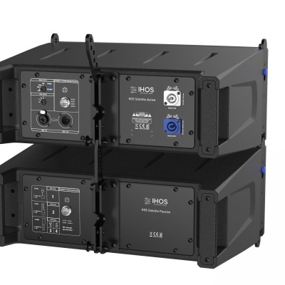 Dois altifalantes áudio profissionais pretos empilhados com painéis traseiros visíveis contendo conectores e etiquetas.