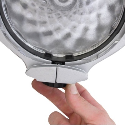 Luz redonda com lente transparente e mão ajustando a parte inferior