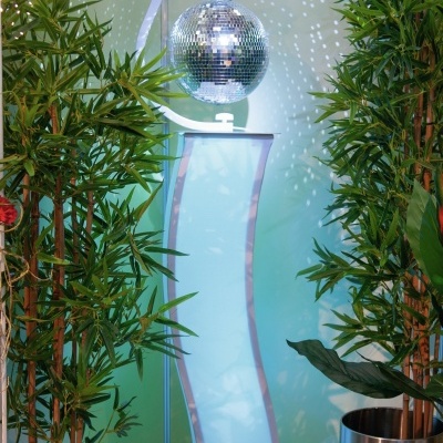 Plantas artificiais com suporte branco e esfera disco espelhada