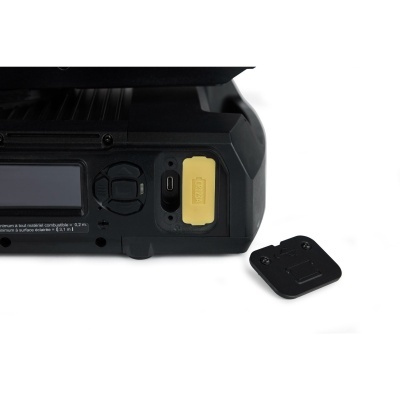 Dispositivo eletrônico preto com ecrã, botões e porta USB com tampa amarela e tampa preta ao lado