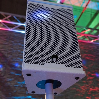 Coluna de altifalante branca com grelha preta em suporte interior colorido