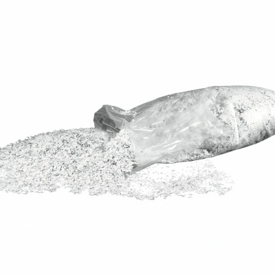 Saco plástico transparente com arroz branco derramado sobre superfície branca