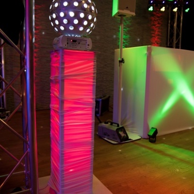 Coluna iluminada rosa com esfera iluminada branca num ambiente interior moderno