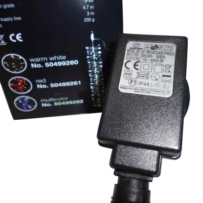 Adaptador de energia preto com etiqueta e embalagem preta com texto