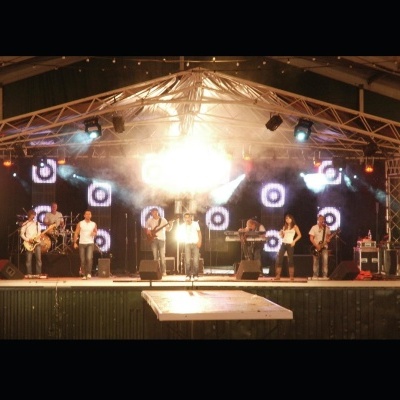 Palco com banda e iluminação em evento ao ar livre