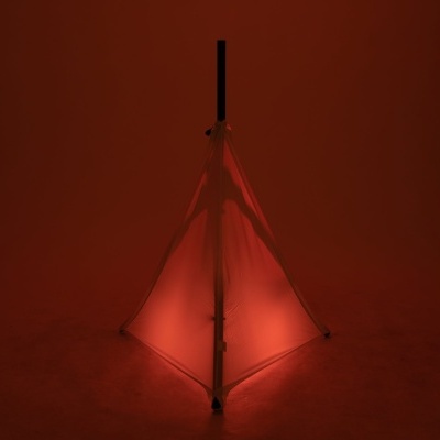 Tenda triangular iluminada com luz vermelha em ambiente escuro