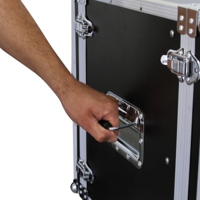 Caixa de transporte preta com cantos metálicos e fechos prateados com uma mão segurando a pega