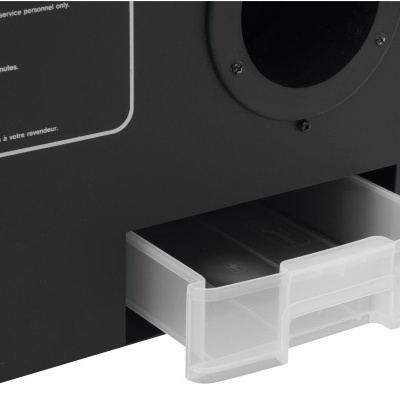 Dispositivo preto com gaveta transparente contendo dois objetos negros.