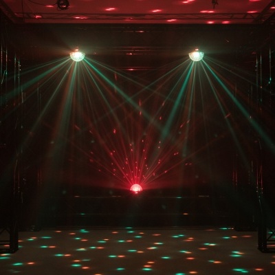 Luzes coloridas de discoteca num espaço escuro com estruturas metálicas