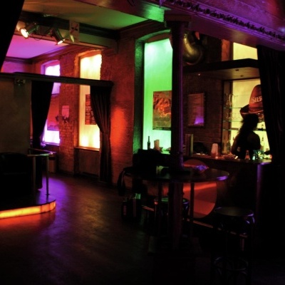 Interior de bar com iluminação colorida e móveis de madeira