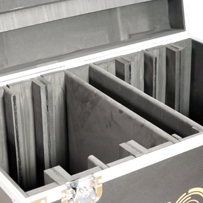 Caixa preta aberta com divisórias em espuma cinza para proteção de objetos