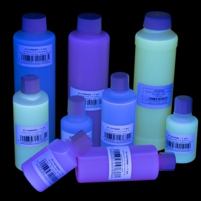 Garrafas coloridas com tampas de rosca e rótulos com códigos de barras sobre fundo preto