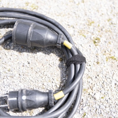 Cabo preto com plugues europeu sobre superfície clara rugosa