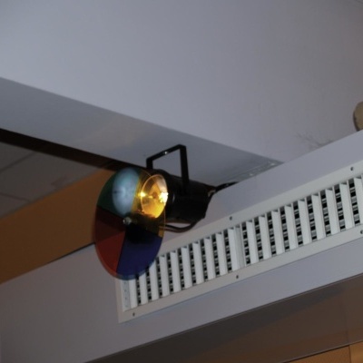 Luz colorida com vidro em quatro cores montada numa parede interior perto de ventilação