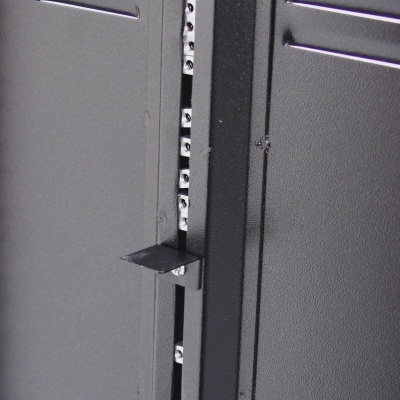 Porta de metal cinzenta com orifícios de ventilação e aba metálica