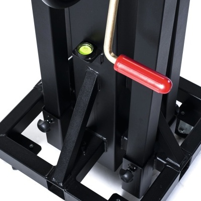 Detalhe de aparelho de fitness metálico preto com manípulo vermelho e nível verde