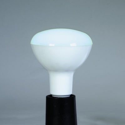 Lâmpada branca numa base preta sobre fundo cinzento