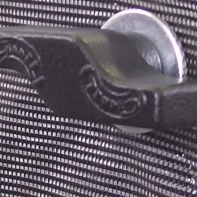 Presilha de metal preto com moeda na superfície quadriculada