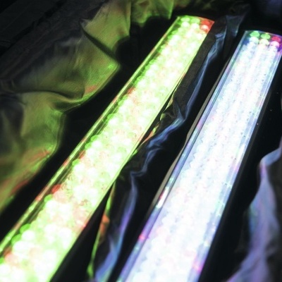 Duas barras de luz LED retangulares em tecido preto, uma com luz verde e vermelha e outra branco com pontos coloridos