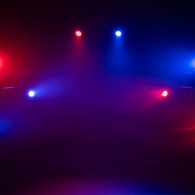 Holofotes com luzes vermelhas e azuis em ambiente escuro