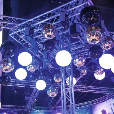 Esferas de espelho e luzes esféricas brancas suspensas em estrutura metálica com iluminação azul