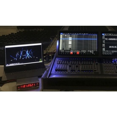 Mesa de som e luzes com portátil e painel digital num auditório escuro