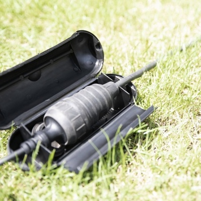 corta-pasto preto numa caixa preta aberta na relva