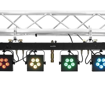 Sistema de iluminação com quatro holofotes quadrados coloridos suspensos numa estrutura metálica.