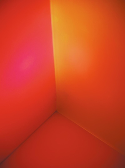 Interior de uma caixa luminosa com paredes laranja e vermelhas