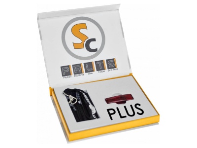 Caixa branca e amarela aberta com dispositivo PLUS, pendrive vermelho e fecho preto dentro.