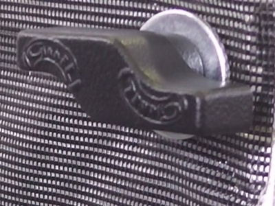 Presilha de metal preto com moeda na superfície quadriculada