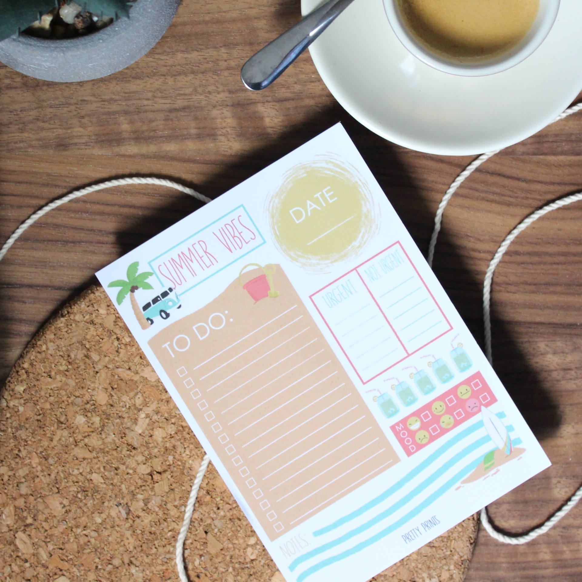 Bloco de notas com decoração de verão, chávena de café e planta pequena sobre mesa de madeira