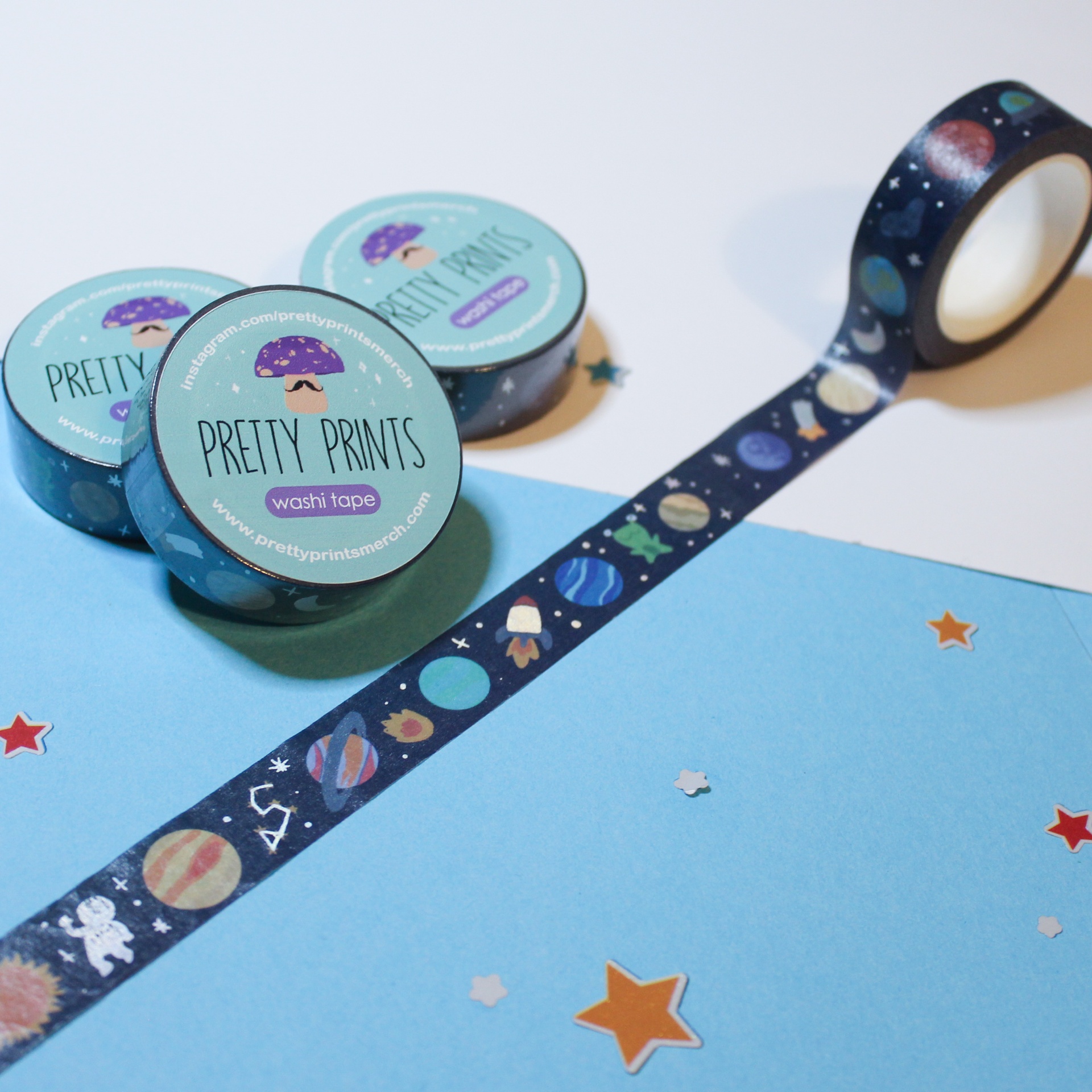 Rolos de washi tape com padrão espacial, papel azul e estrelas adesivas
