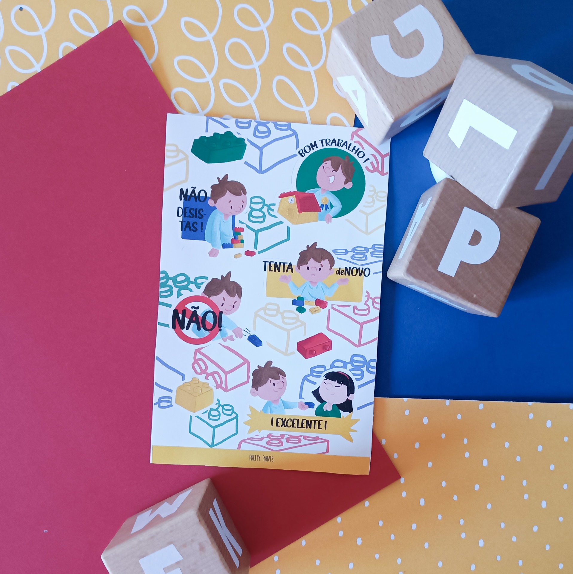 Cartão ilustrado com crianças e blocos de construção, rodeado por blocos de madeira com letras sobre folhas coloridas