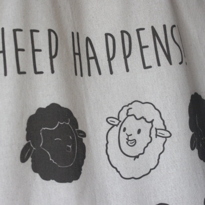 Tecido claro com estampa de ovelhas e texto SHEEP HAPPENS